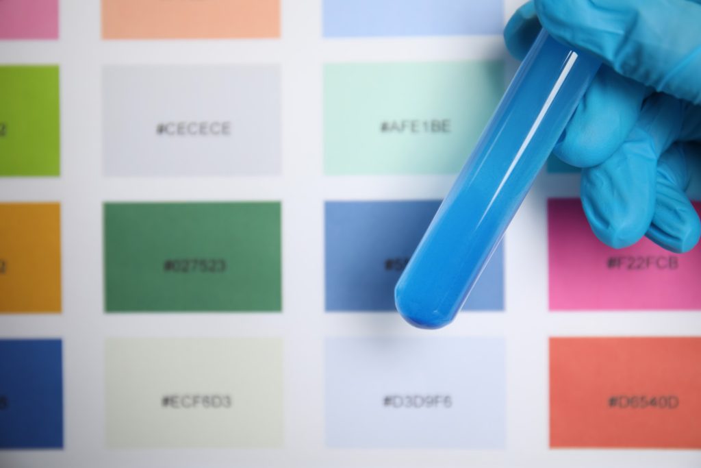 Doctor holding test tube with liquid near sample chart closeup